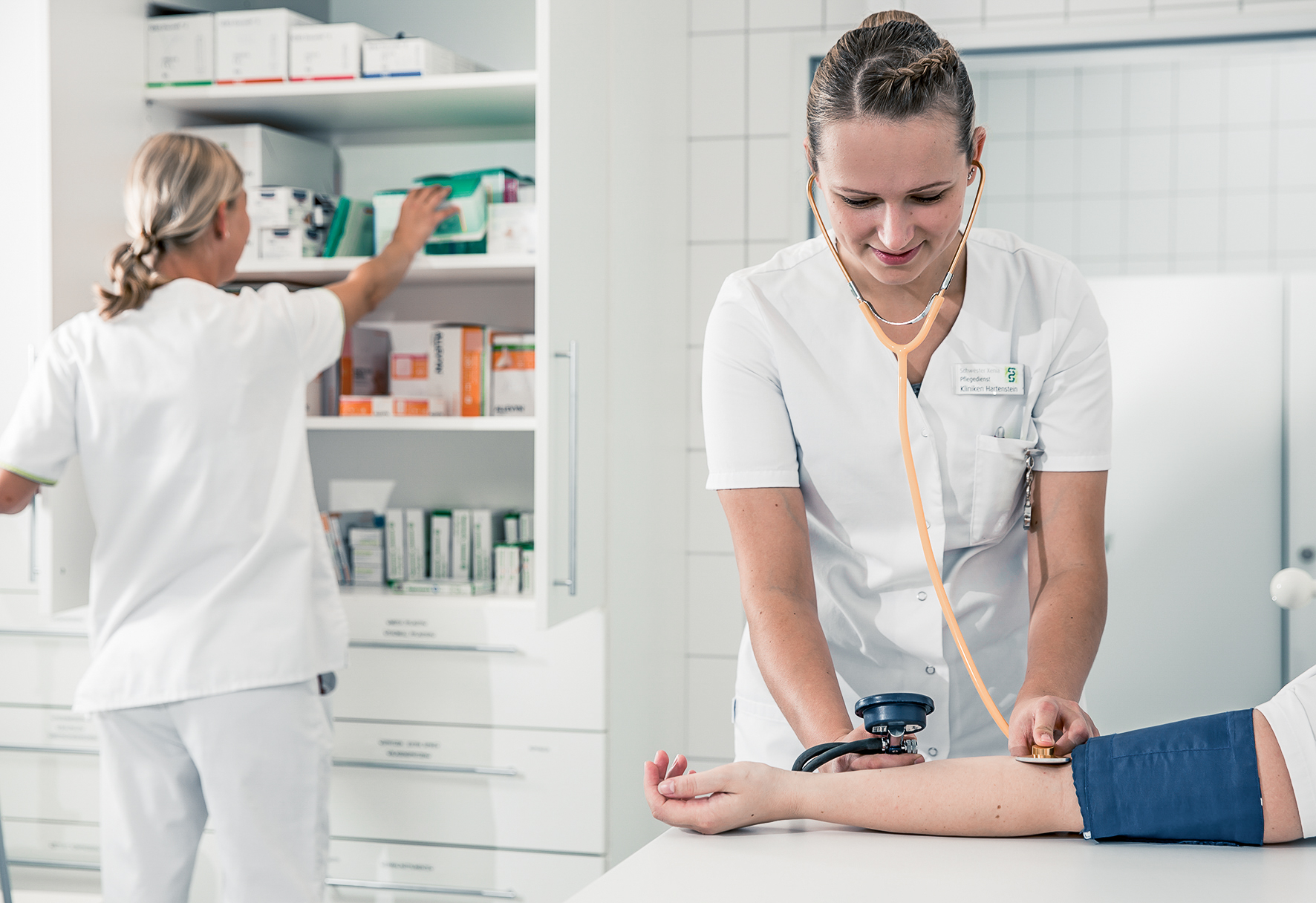 Pflegekraft misst Blutdruck eines Patienten